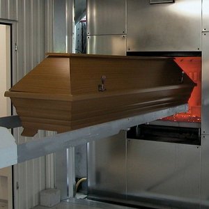 Sarg fährt in den Ofen eines Krematoriums ein