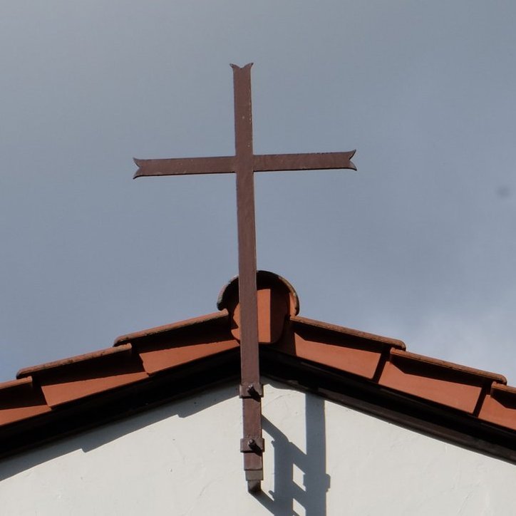 Friedhofskapelle mit Kreuz am Dach und der Aufschrift RIP