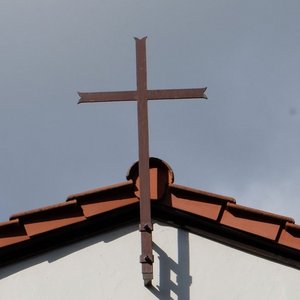 Friedhofskapelle mit Kreuz am Dach und der Aufschrift RIP
