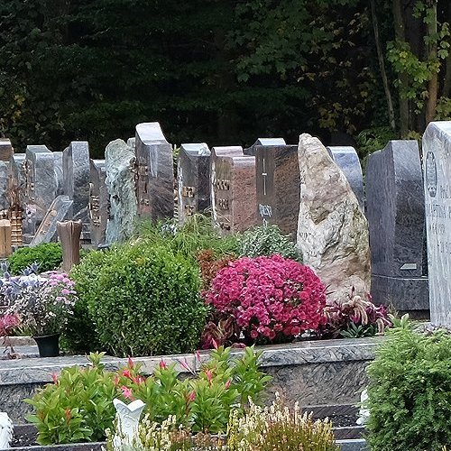 Reihe von Grabmalen und Gräbern auf einem Friedhof