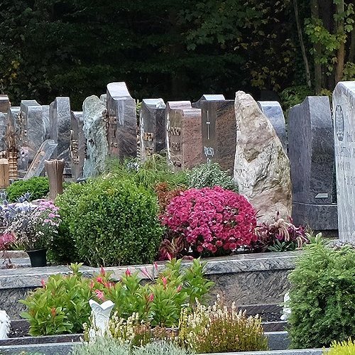 Reihe von Grabmalen und Gräbern auf einem Friedhof