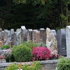 Reihe von Grabmalen und Gräbern auf einem Friedhof