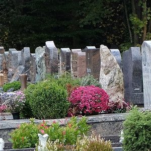 Reihe von Grabmalen und Gräbern auf einem Friedhof