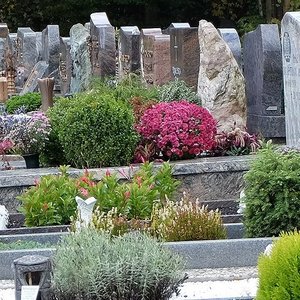 Reihe von Grabmalen und Gräbern auf einem Friedhof