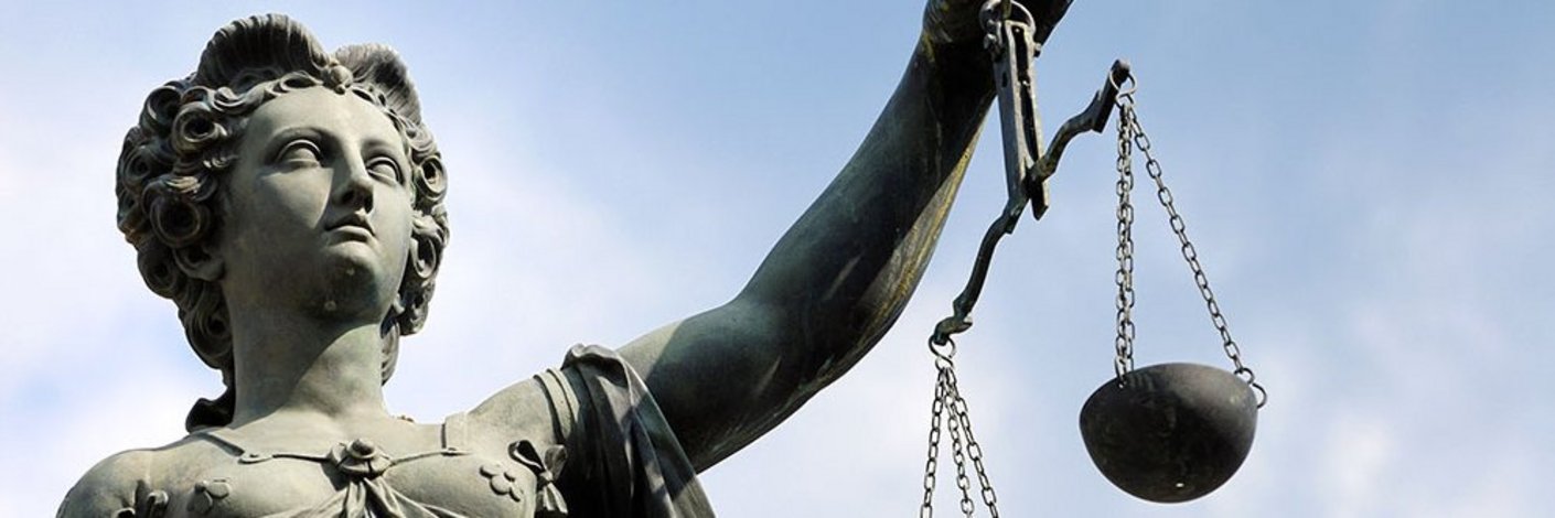 Justitia-Statue mit geschlossenen Augen und Waage in der Hand
