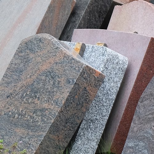 Ausgemusterte Grabsteine lehnen an einer Wand