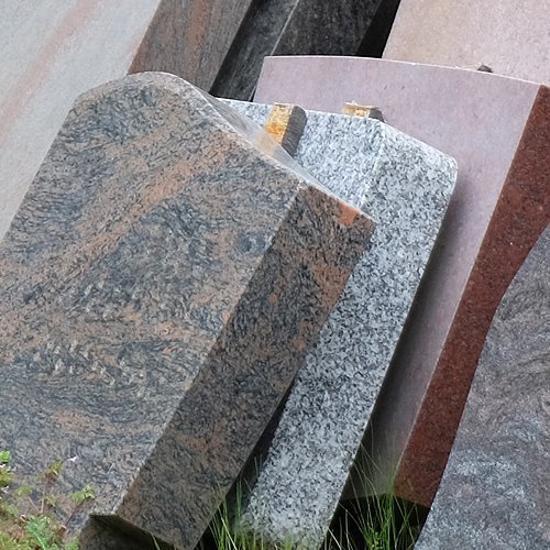 Ausgemusterte Grabsteine lehnen an einer Wand