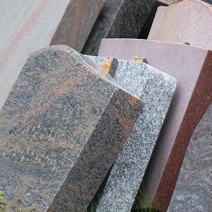 Ausgemusterte Grabsteine lehnen an einer Wand