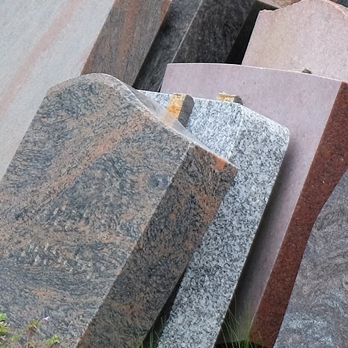 Ausgemusterte Grabsteine lehnen an einer Wand