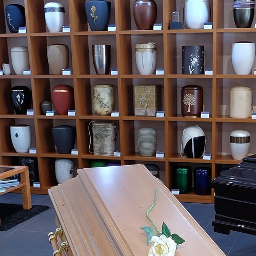 Urnenausstellung mit Sarg im Bestattungshaus