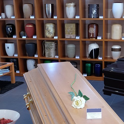 Urnenausstellung mit Sarg im Bestattungshaus
