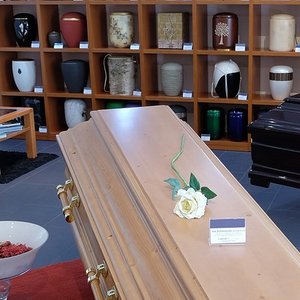 Urnenausstellung mit Sarg im Bestattungshaus