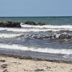 Wellen und Felsen am Sandstrand