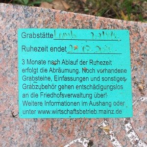 Aufkleber auf Grabstein mit Hinweis auf Ablauf der Nutzungsdauer