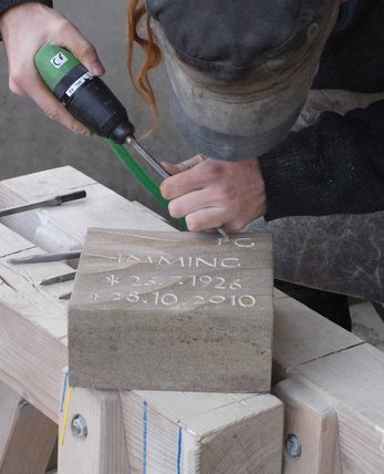 Steinmetz haut Schrift in ein Grabzeichen