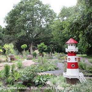 Grabfeld mit kleinem Leuchtturm auf Friedhof