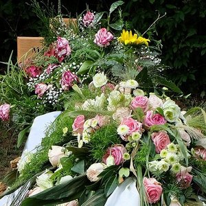 Blumenschmuck und Kränze auf der Grabstelle nach einer Bestattung