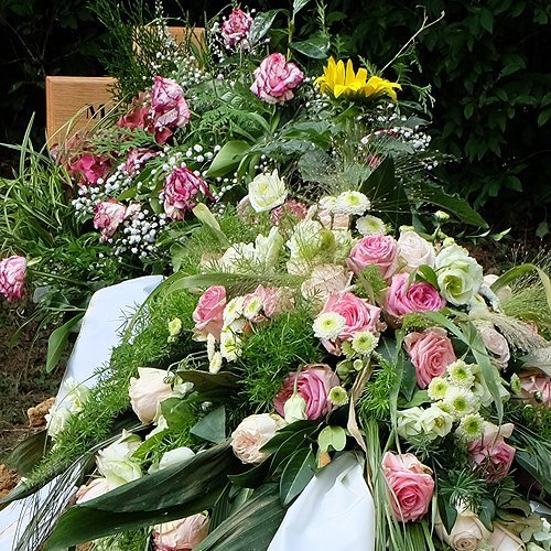 Blumenschmuck und Kränze auf der Grabstelle nach einer Bestattung