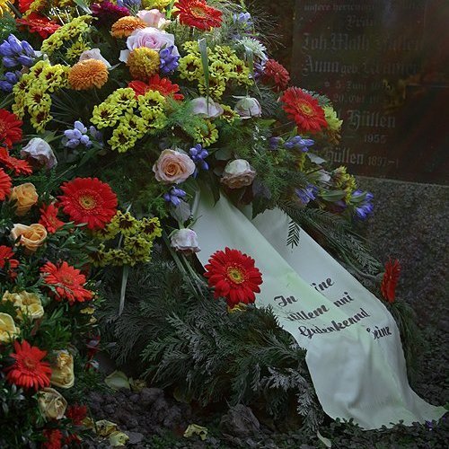 Blumen und Kranz auf einer Grabstelle