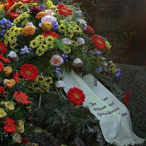 Blumen und Kranz auf einer Grabstelle