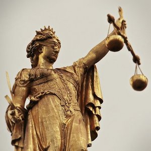 Justitia-Statue mit verbundenen Augen und Waage in der Hand