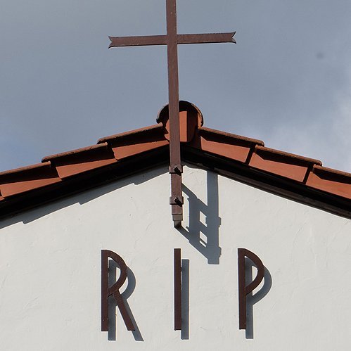 Kreuz und Schrift RIP am Giebel einer Trauerhalle